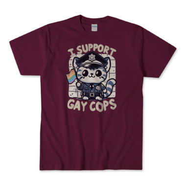 A maroon T-shirt featuring a cute kitten dressed in a police uniform, holding a rainbow flag. The kitten has a friendly and supportive expression. The text "I support gay cops" is displayed in a bold, playful font above and below the kitten. The background is simple and clean, allowing the main elements to stand out prominently. By Left Arrow Tees Company.